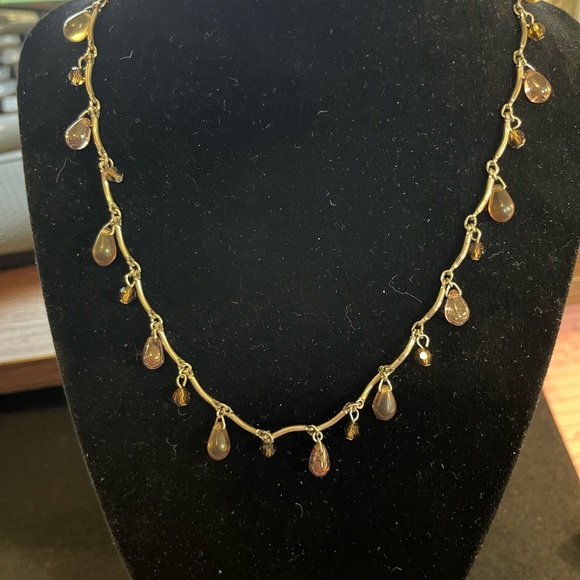 Jewelry - Brown teardrop beads surround the silver tone necklace.